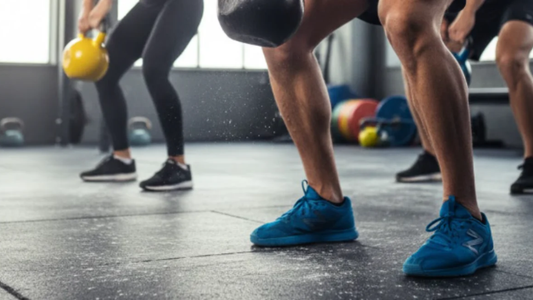People performing kettlebell exercises during a group strength training workout in a gym