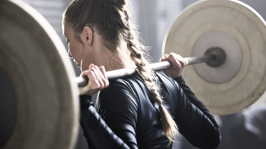 Woman performing a barbell squat as part of functional strength training for full-body strength and stability