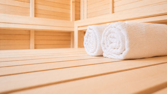 Infrared sauna bench with folded towels in natural light for post-workout recovery 