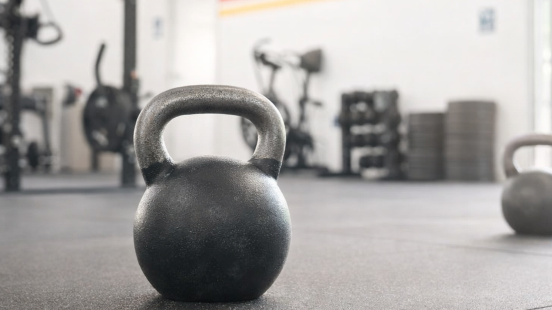 Black kettlebell on gym floor used for kettlebell training workouts.